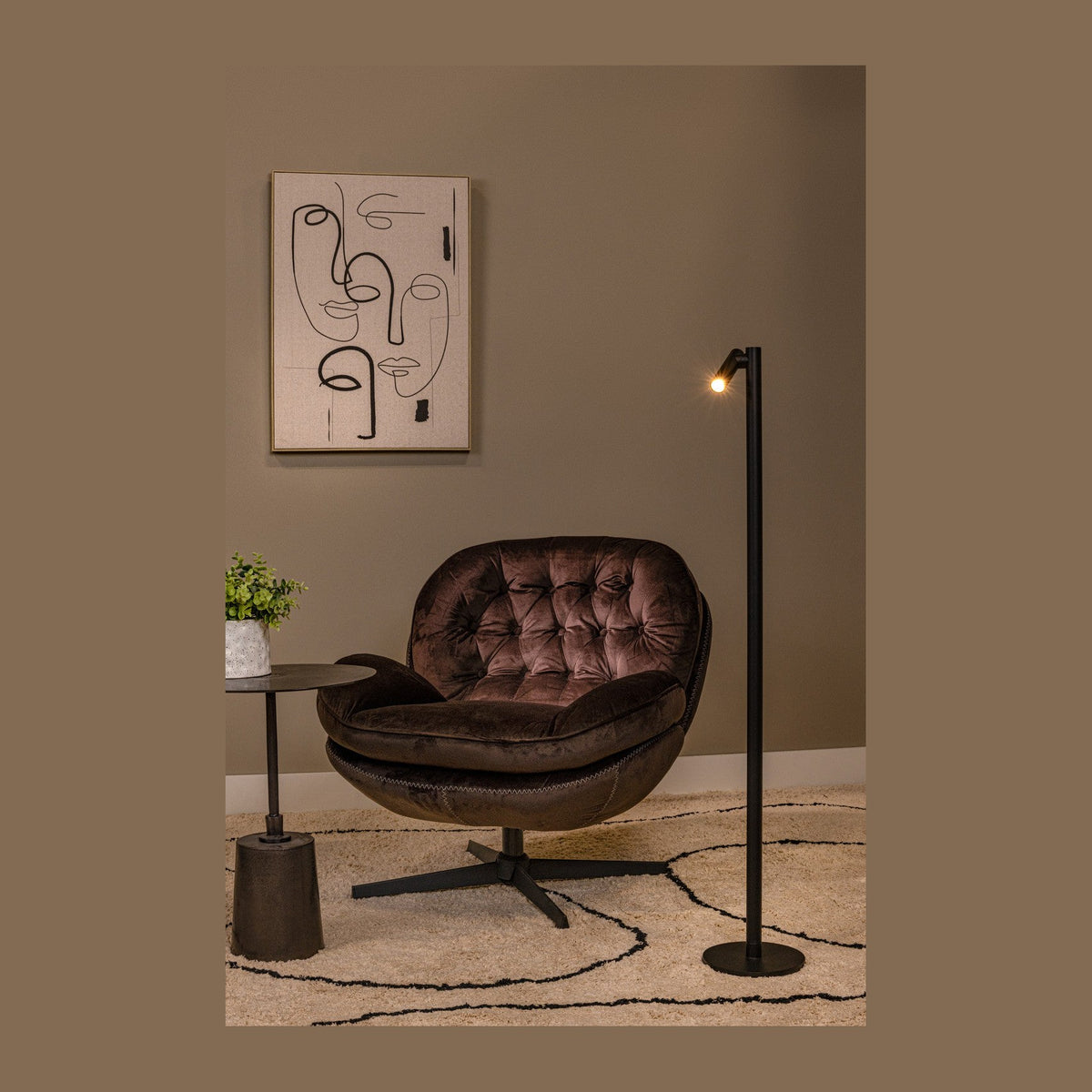 Mise en ambiance du lampadaire noir près d'un fauteuil en velours et d'un tableau abstrait