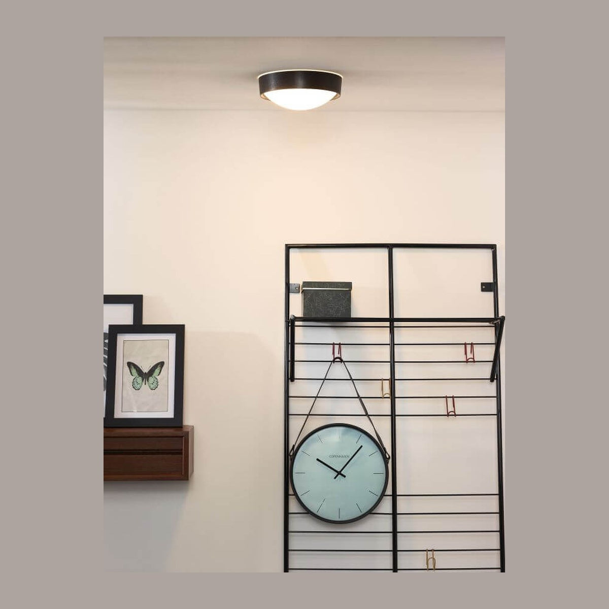 Plafonnier rond allumé au plafond d'un salon, ambiance déco avec horloge murale