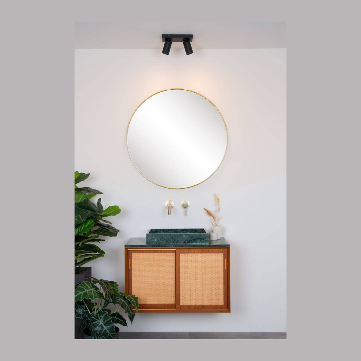 Vue d'ensemble du plafonnier au-dessus d'un miroir rond, salle de bain claire