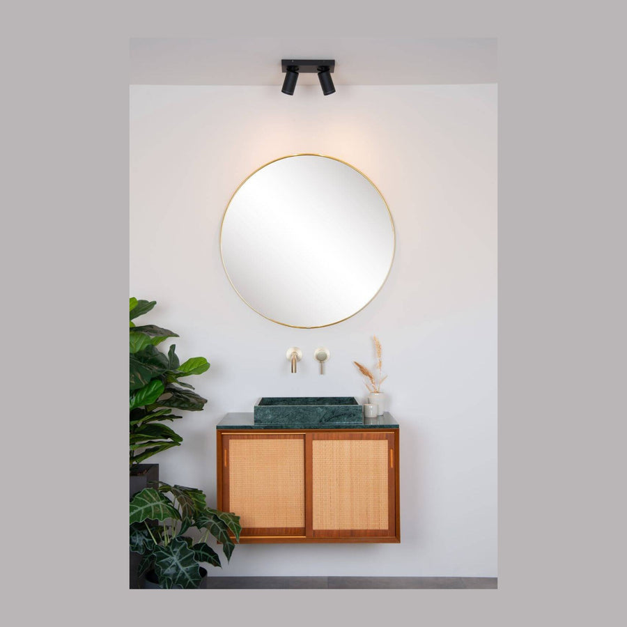 Vue d'ensemble du plafonnier au-dessus d'un miroir rond, salle de bain claire