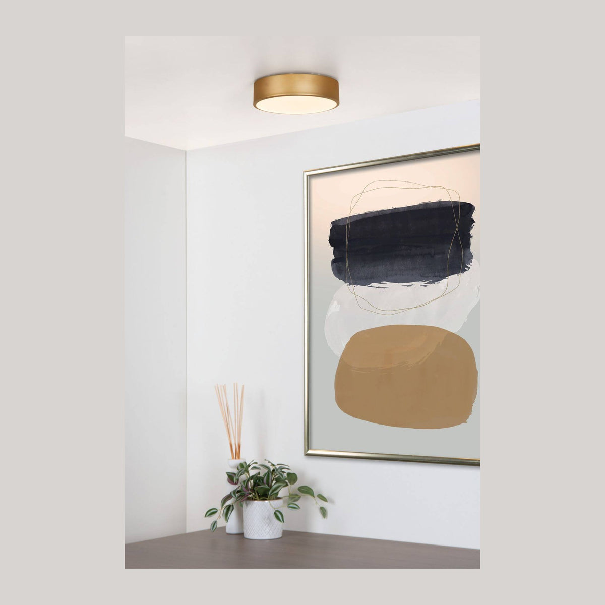 Plafonnier doré mat et opale fixé au plafond dans un salon blanc, mise en ambiance