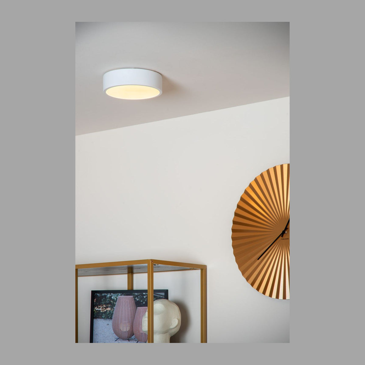 Plafonnier blanc rond fixé au plafond, éclairé, dans un intérieur clair