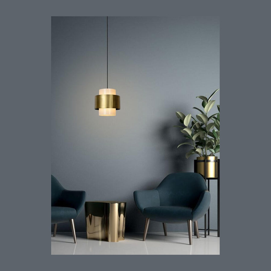 Suspension dorée allumée au-dessus d'un salon aux fauteuils bleus, mur gris