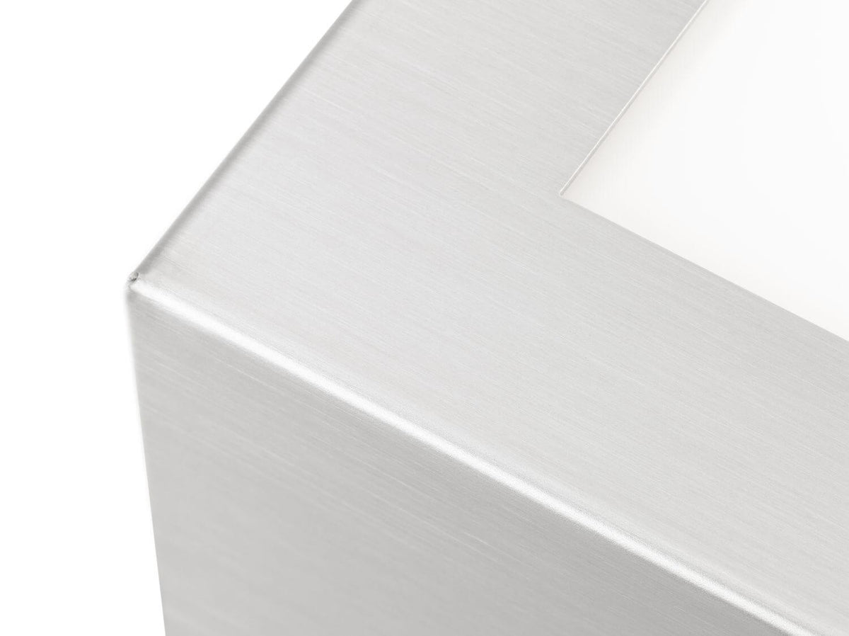 Gros plan sur l'angle et la finition brossée de l'applique en inox.