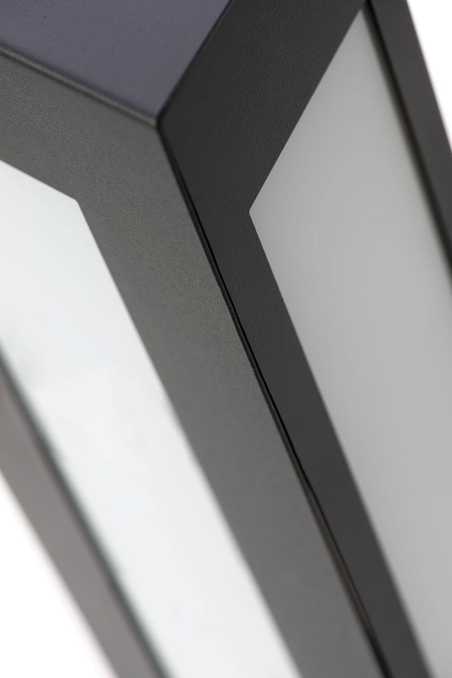 Détail rapproché d'un angle du cadre métallique et de la surface diffusante blanche.