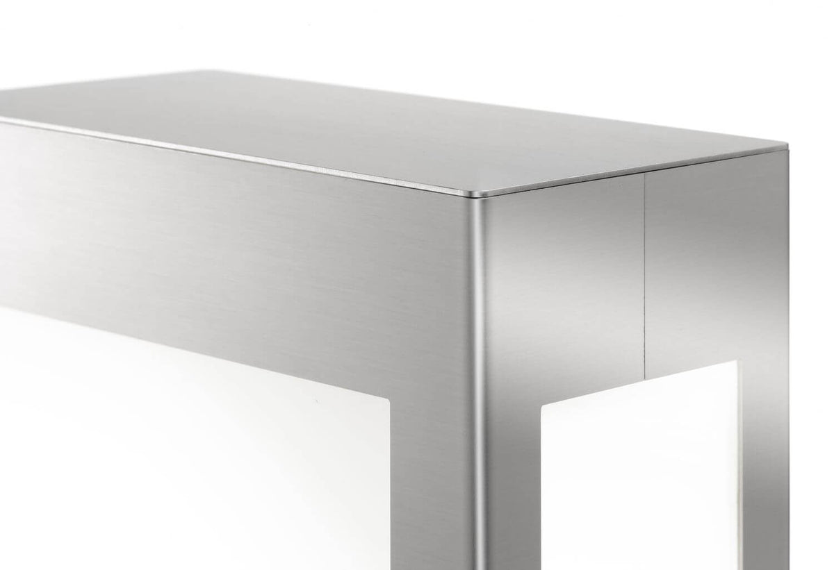Détail du coin supérieur en inox brossé et de la fenêtre lumineuse blanche.