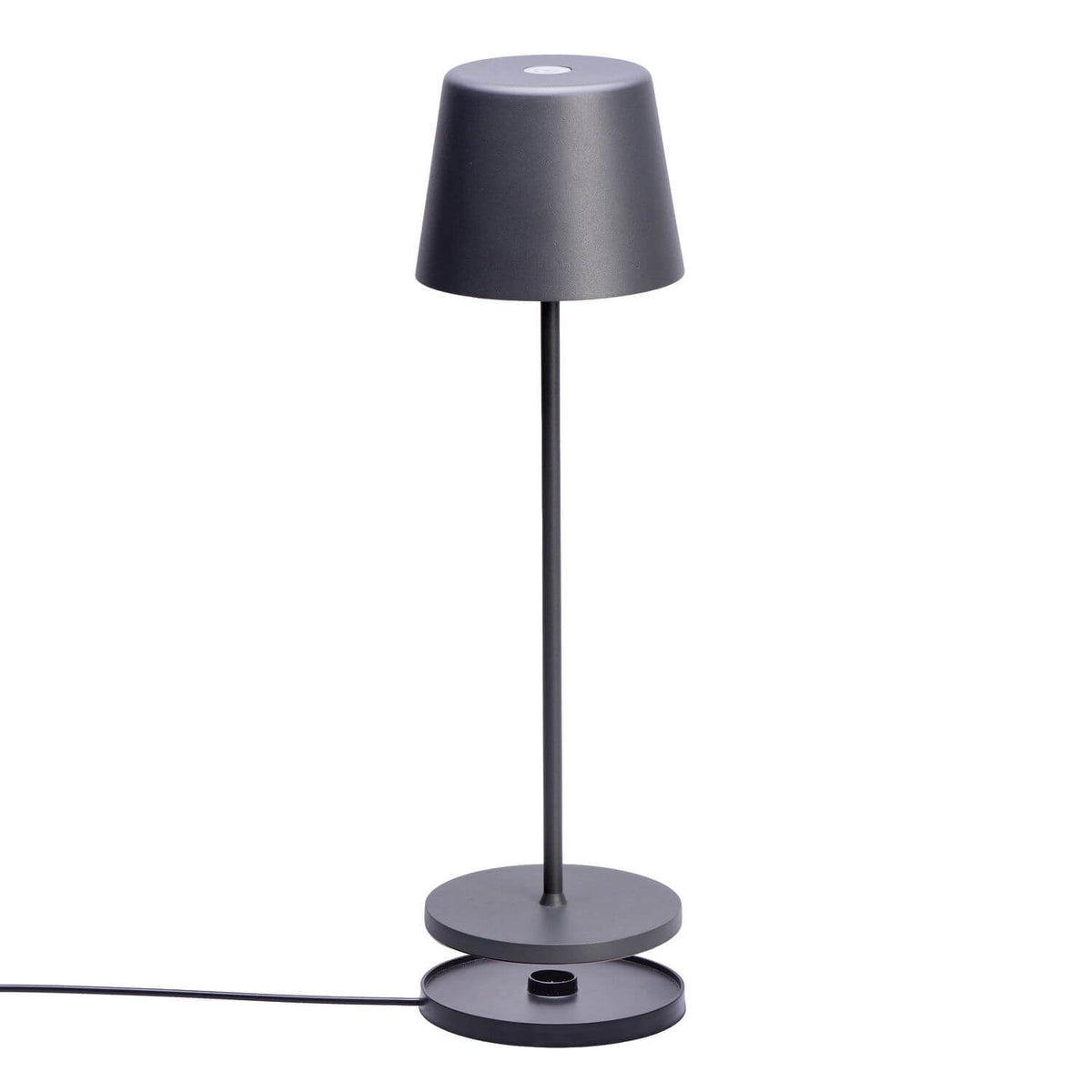 Vue de trois quarts de la lampe posée sur sa base de recharge.