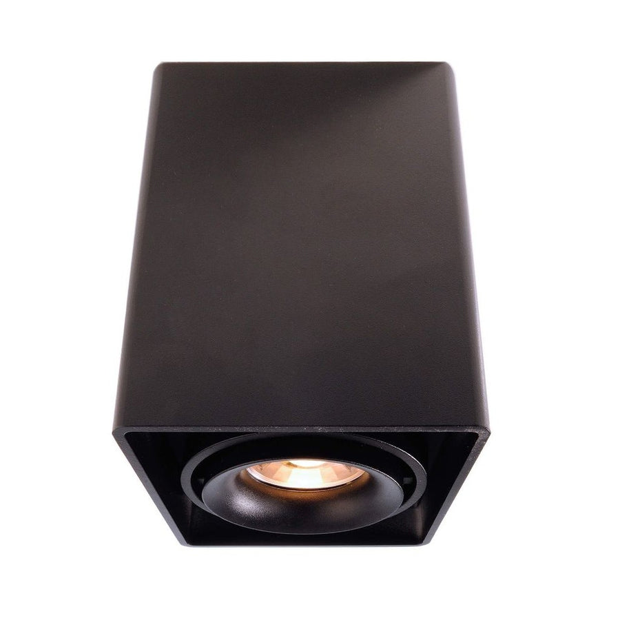 Spot noir rectangulaire vu de trois quarts, réflecteur rond et ampoule allumée.