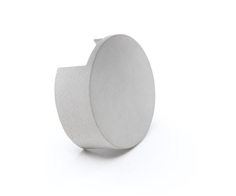 Vue en biais de l’applique montrant le disque et le corps cylindrique en béton.