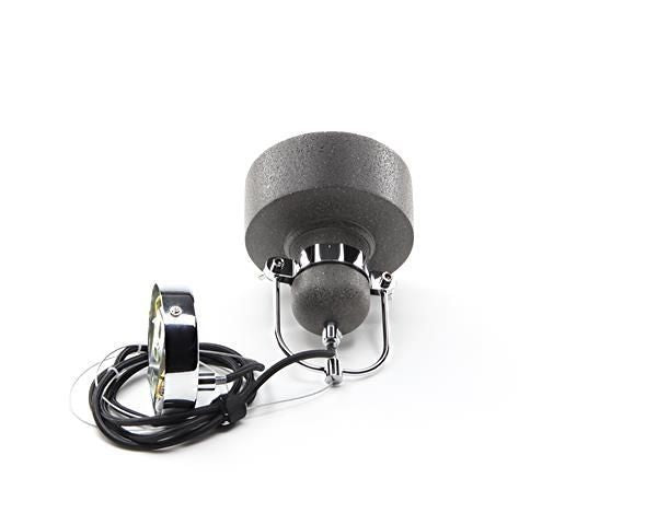 Vue du luminaire couché avec le câble noir enroulé et le support chromé.