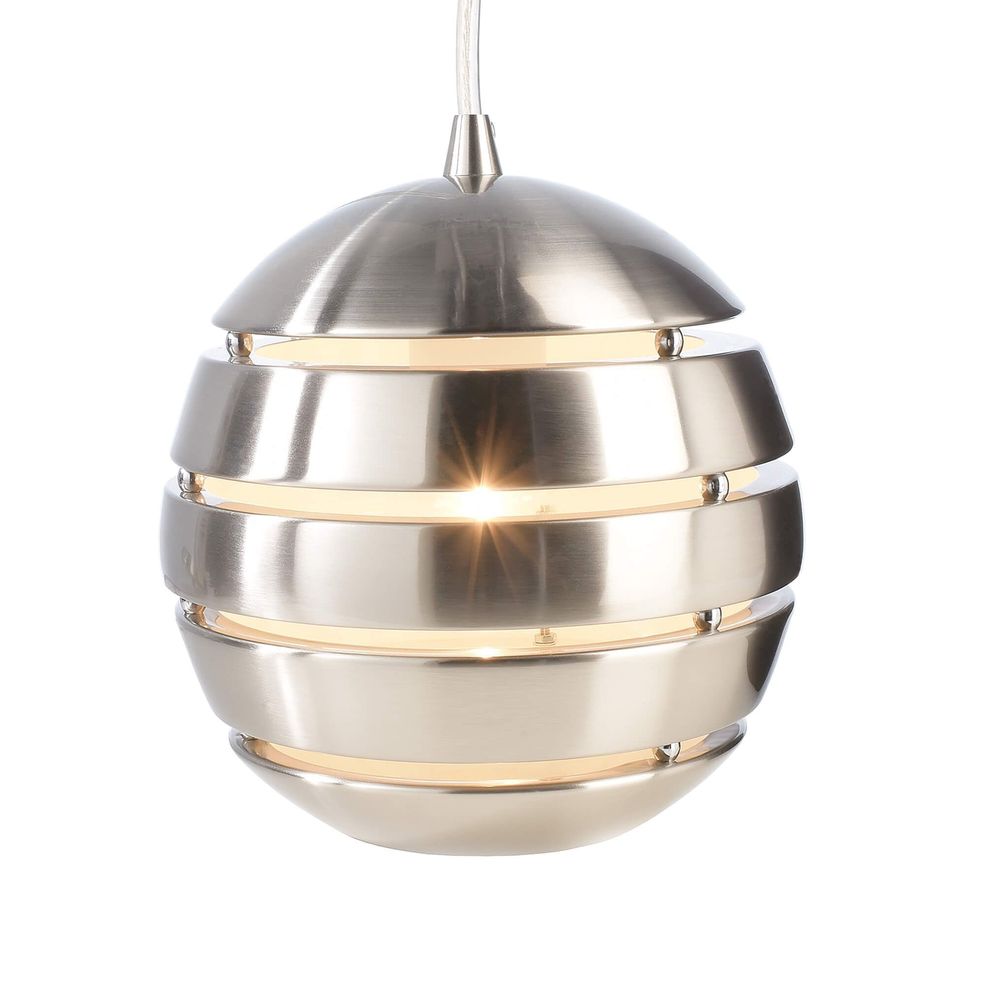 Détail rapproché de la sphère inox ajourée, lumière chaude visible entre les bandes.