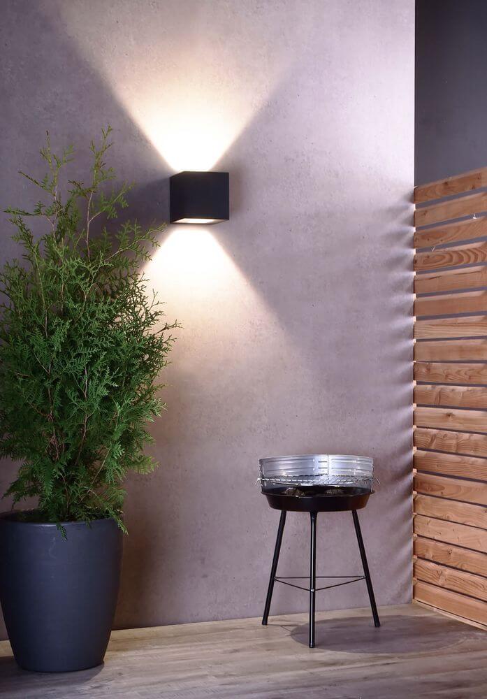 Mise en ambiance extérieure montrant les faisceaux hauts et bas sur un mur texturé
