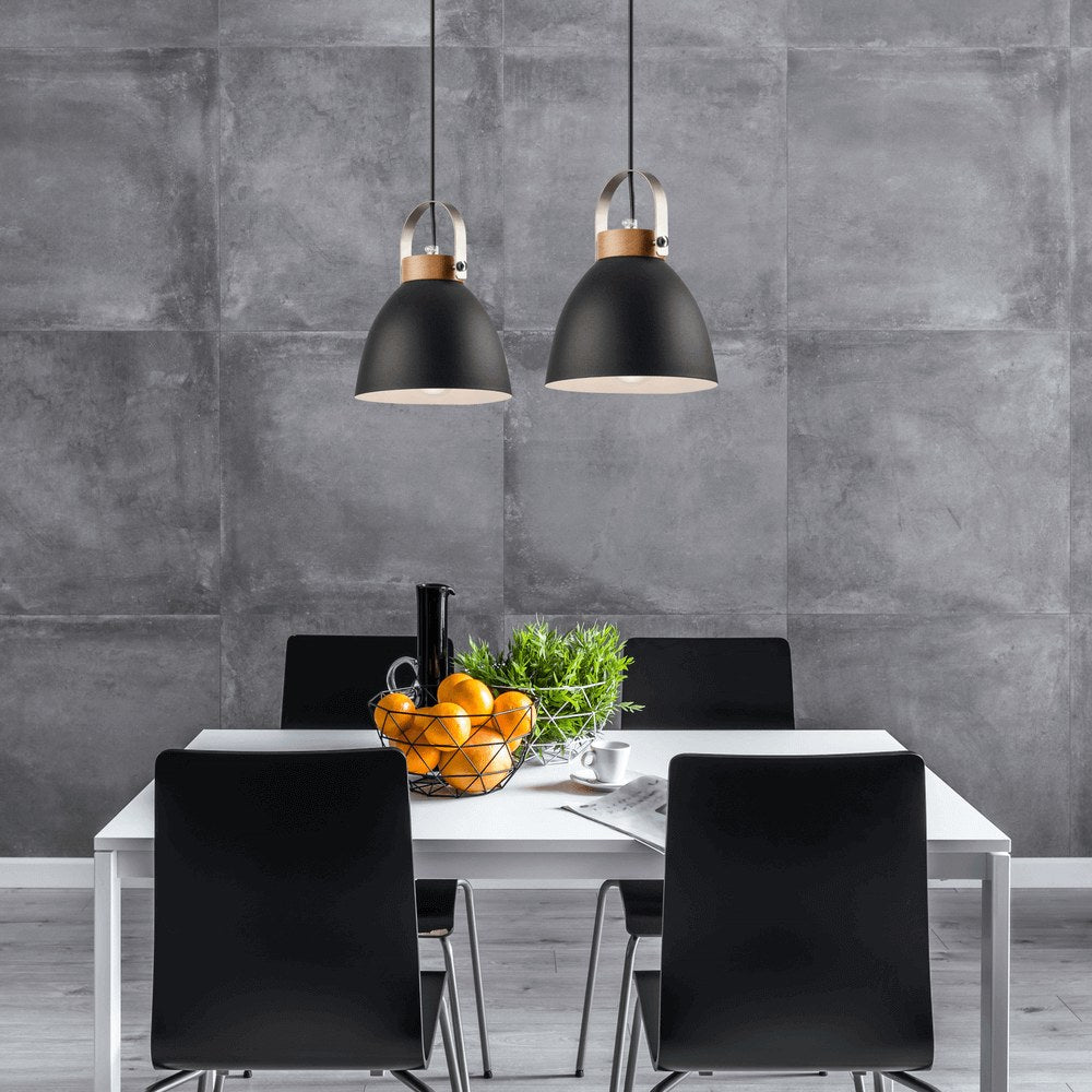 Mise en ambiance au-dessus d'une table blanche, deux suspensions noires éclairant une salle à manger moderne.