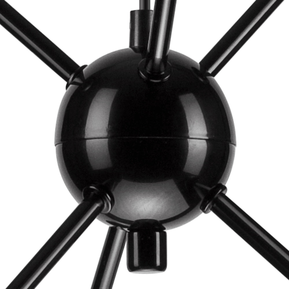 Gros plan sur la sphère centrale noire et les raccords des bras métalliques rayonnants.