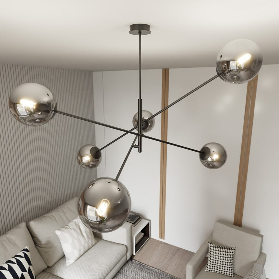 Vue en plongée du plafonnier, gros globes fumés devant le canapé et le fauteuil