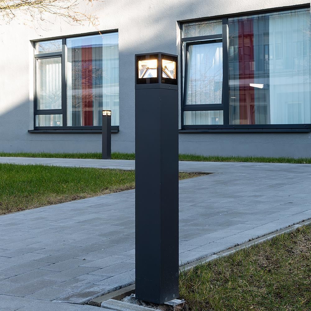 Borne carrée anthracite installée le long d'une allée devant des fenêtres