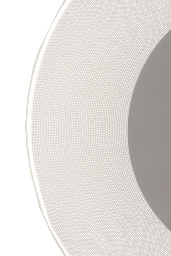Détail macro du diffuseur blanc perforé et du bord du disque central argenté.