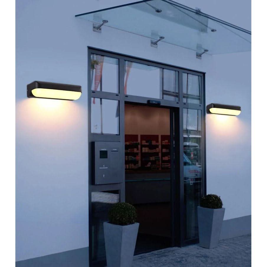 Mise en ambiance extérieure : deux appliques encadrant une porte vitrée, lumière chaude au crépuscule