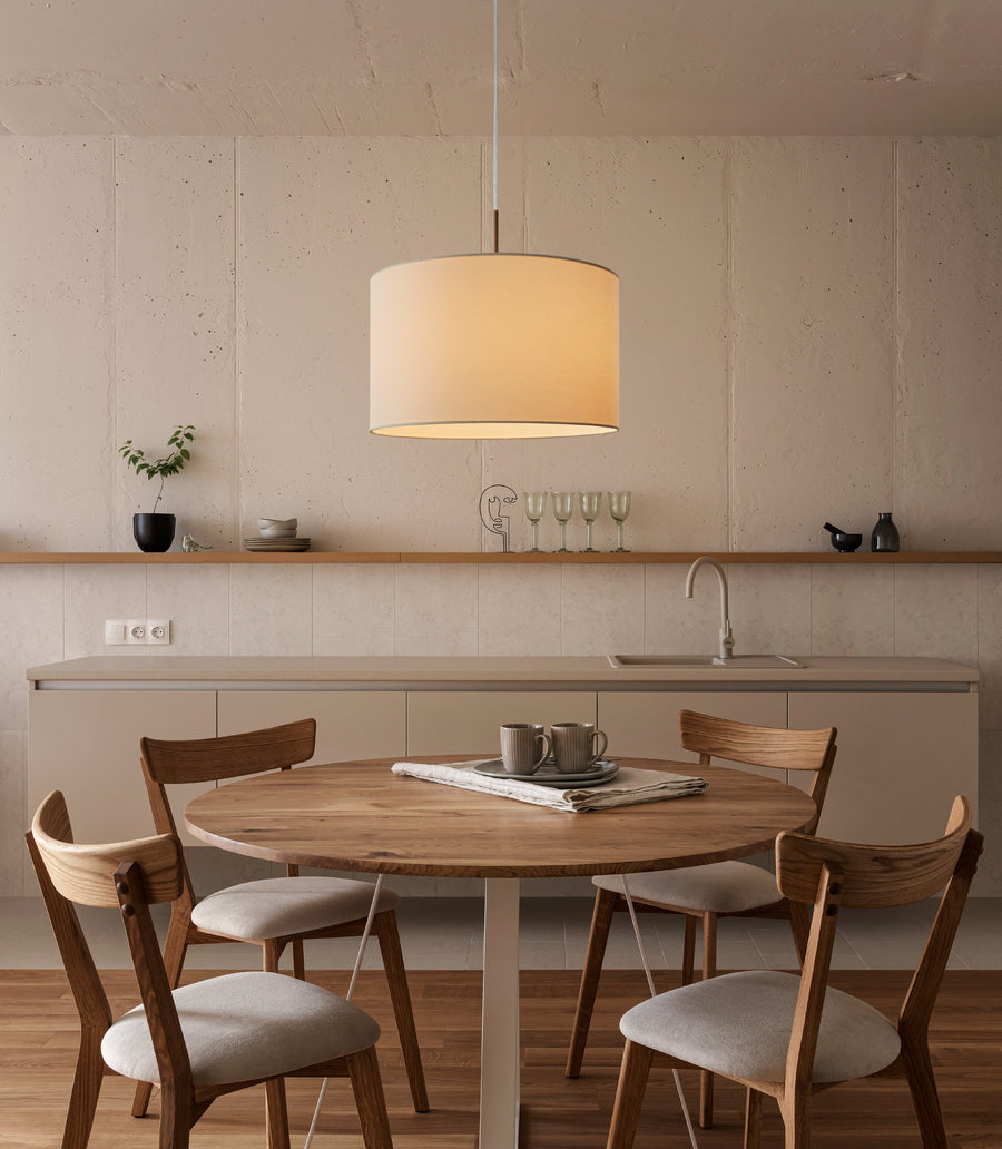 Suspension éclairée au-dessus d'une table ronde en bois dans une cuisine