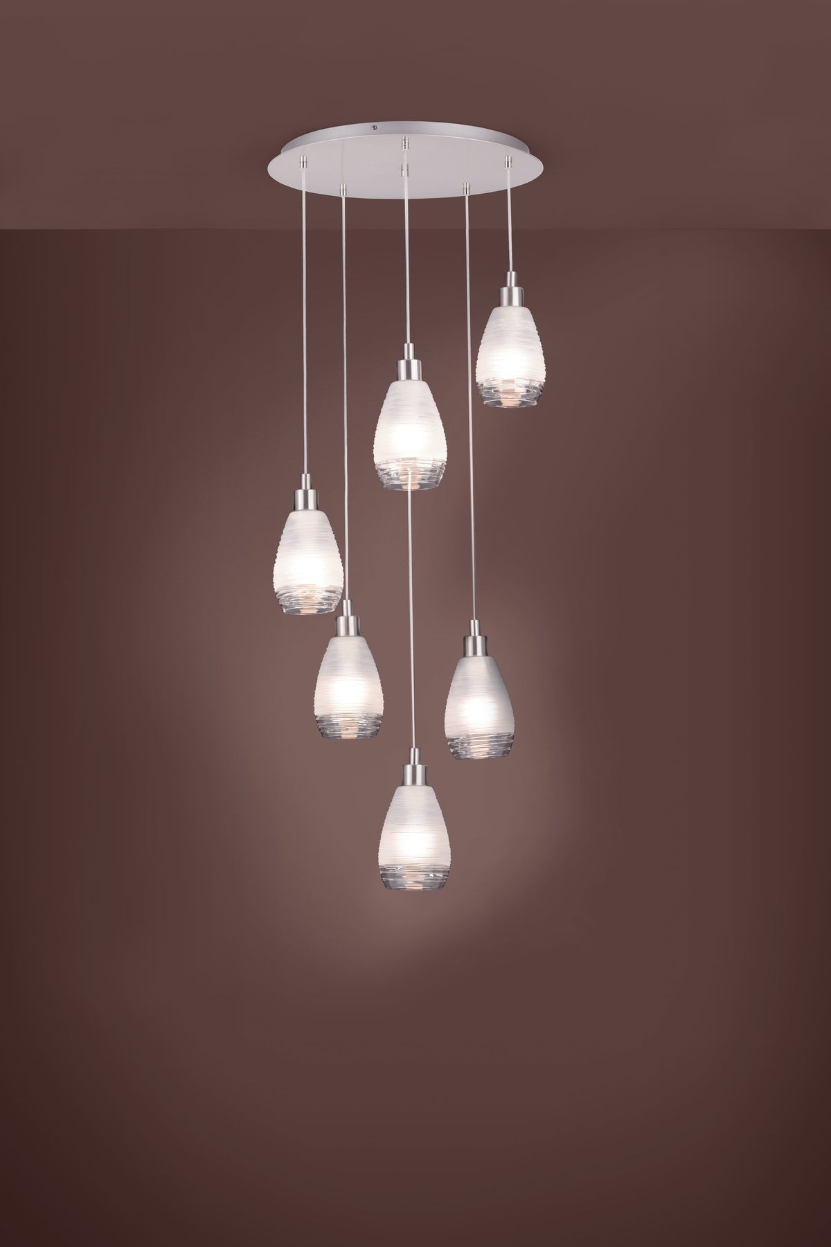 Mise en ambiance du luminaire allumé, suspension installée sur fond marron