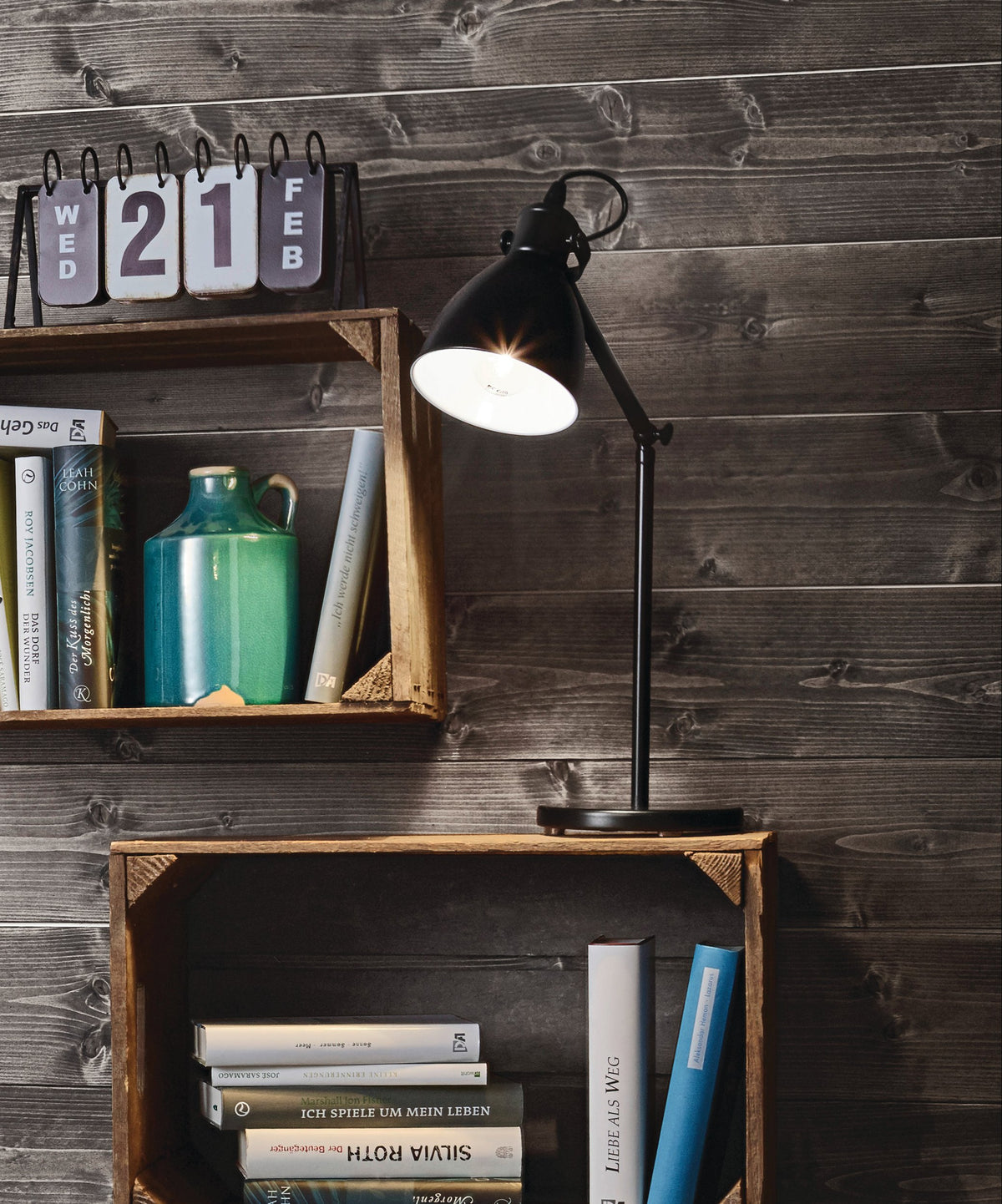Mise en ambiance : lampe posée sur une étagère en bois devant un mur lambrissé