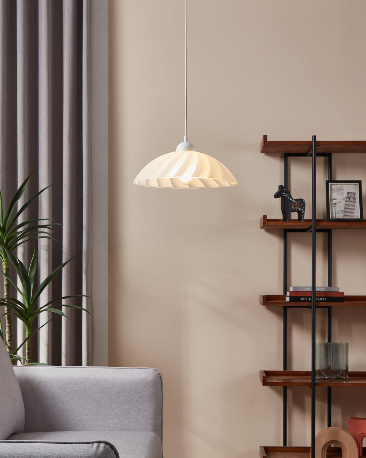 Mise en ambiance salon : la suspension blanche allumée éclaire un mur beige