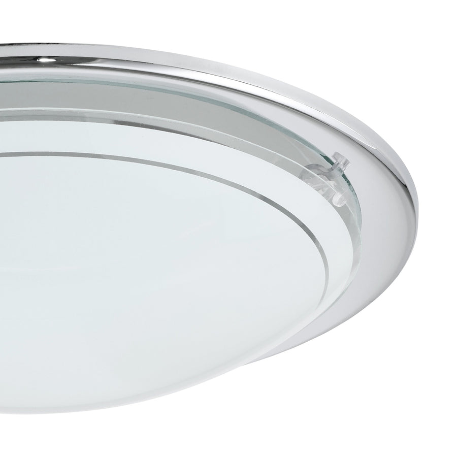 Gros plan sur le bord chromé, le verre et la fixation du luminaire.