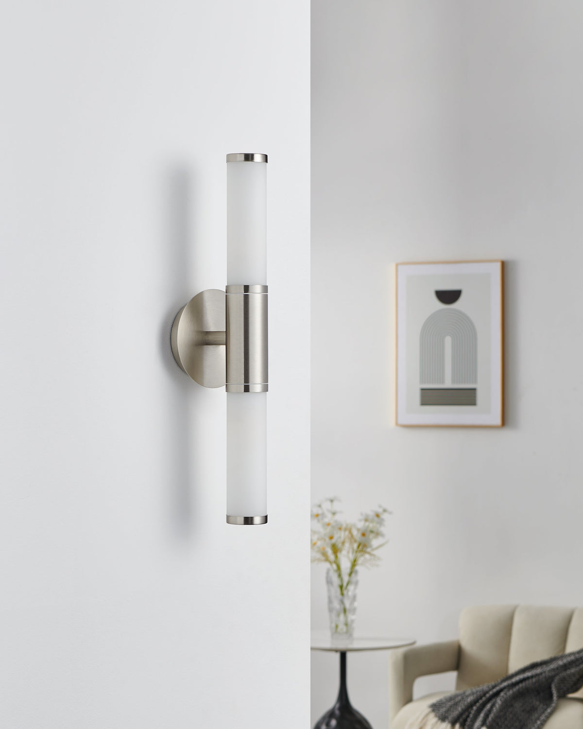 Même applique murale éteinte sur mur blanc, cadre et fauteuil beige en arrière-plan