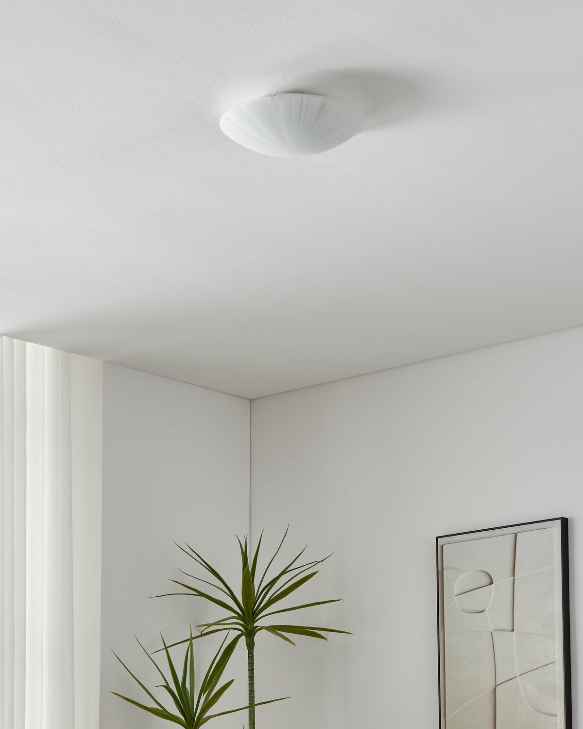 Plafonnier éteint fixé au plafond dans un intérieur blanc épuré