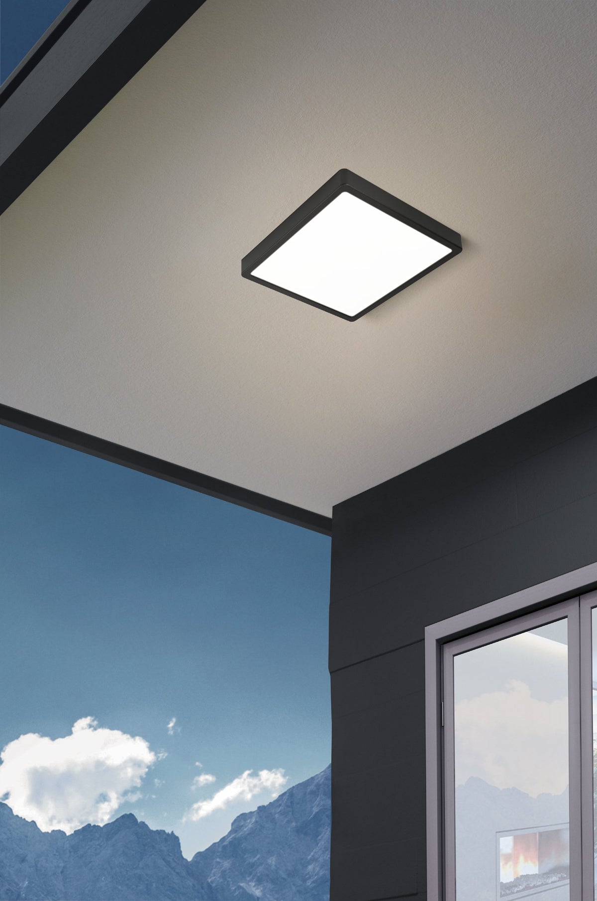 Luminaire extérieur monté au plafond sous un auvent face à la montagne.