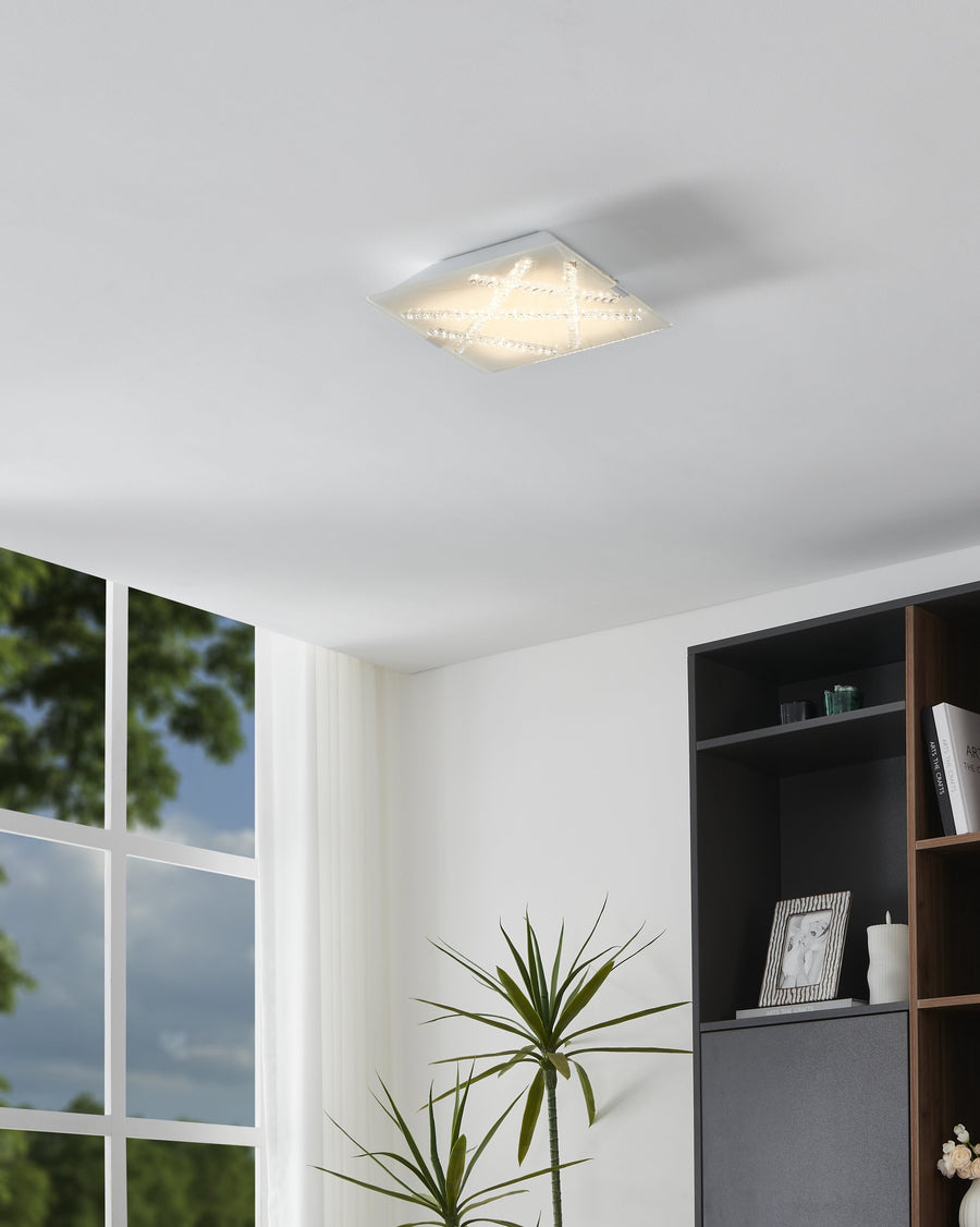 Luminaire allumé monté au plafond dans un salon moderne avec bibliothèque et plante verte