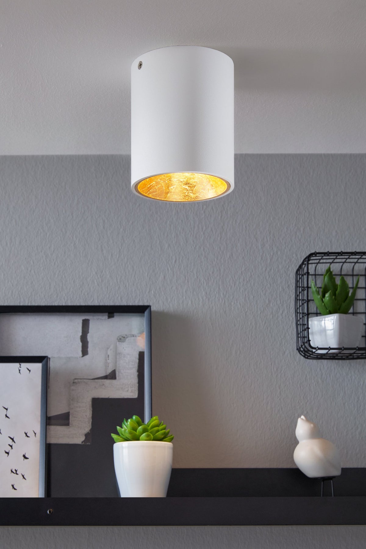 Mise en ambiance du plafonnier blanc allumé, fixé au plafond d'un intérieur gris