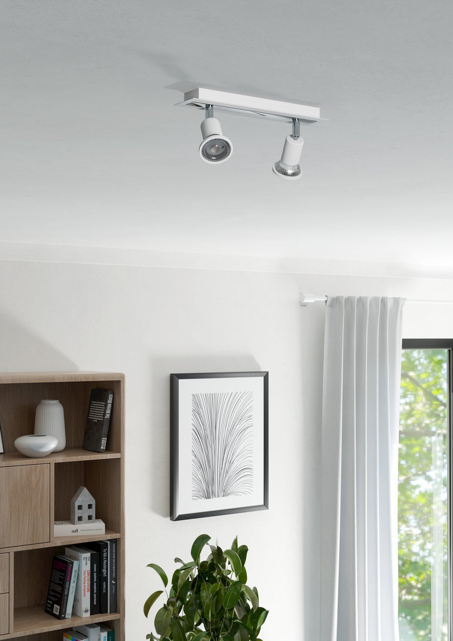 Version blanche du spot installée au plafond, éclairant une pièce lumineuse.