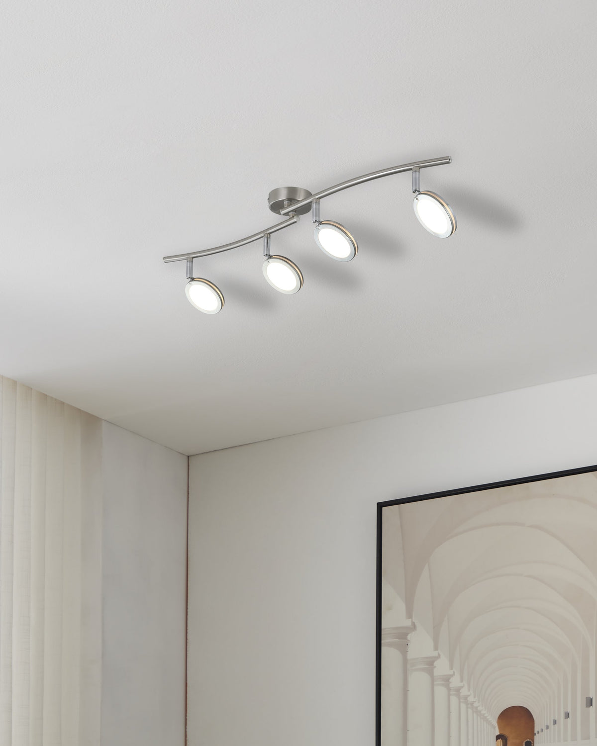 Mise en ambiance au plafond dans un intérieur clair, avec rideaux et cadre mural.