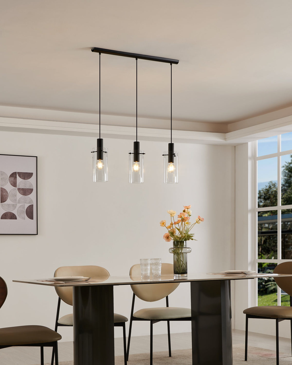 Suspension trois lumières allumées au-dessus d'une table à manger dans une pièce lumineuse.