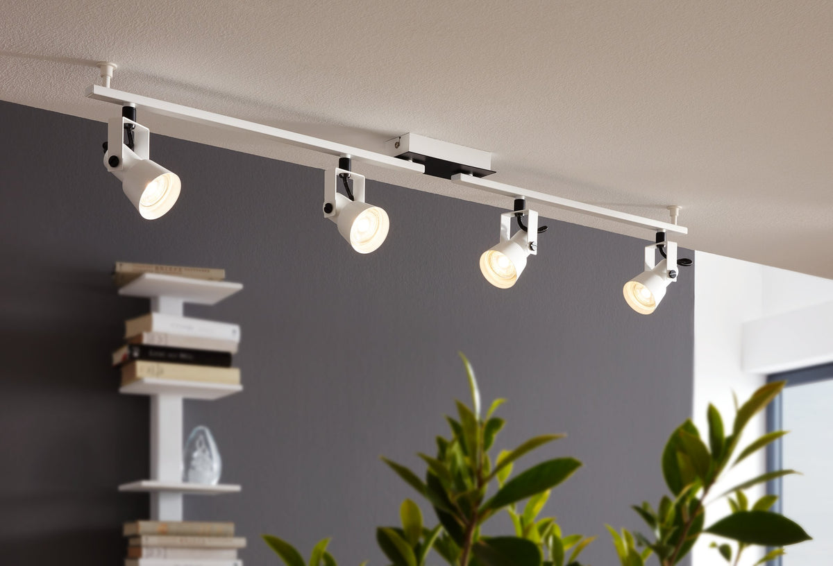 Mise en ambiance du spot plafond blanc quatre têtes allumées dans un salon moderne