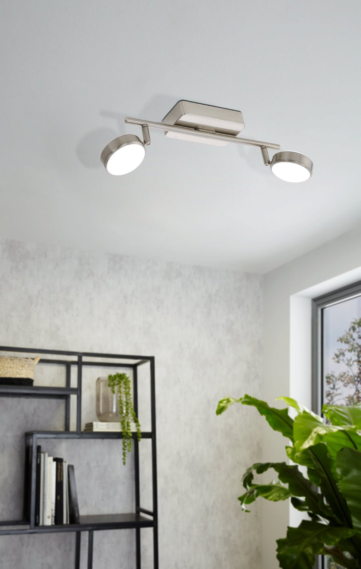 Mise en ambiance du luminaire fixé au plafond dans un salon avec étagère et plante