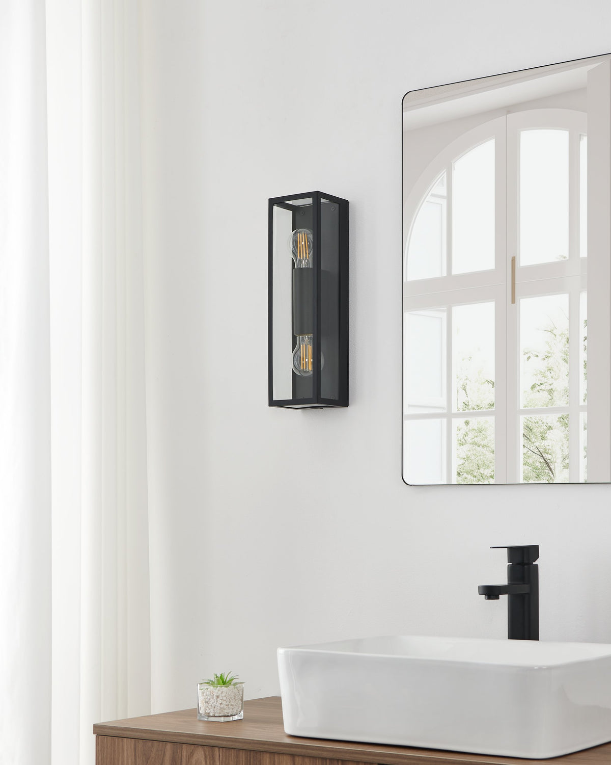 Ambiance murale avec applique éclairée, miroir et robinetterie noire à proximité