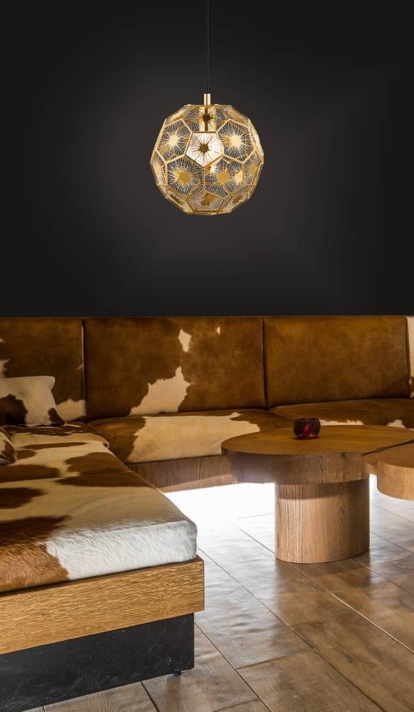 Suspension allumée au-dessus d'une banquette en cuir de vache, ambiance chaleureuse.