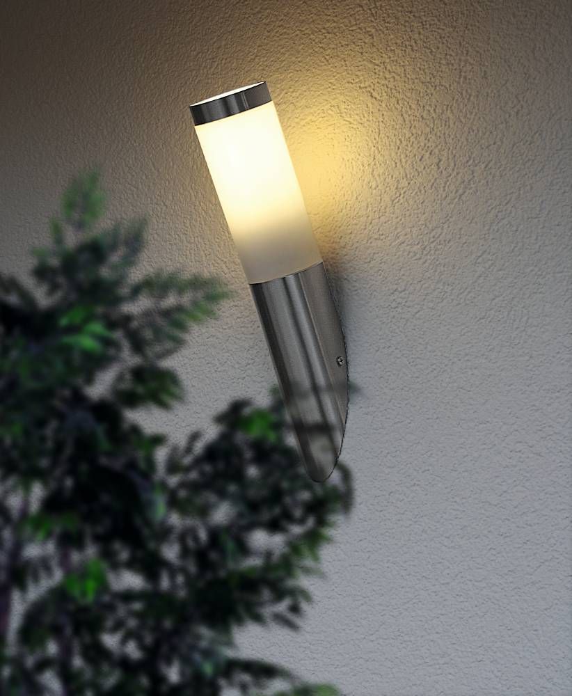 Mise en ambiance nocturne sur mur crépis, halo lumineux chaud près d'un feuillage