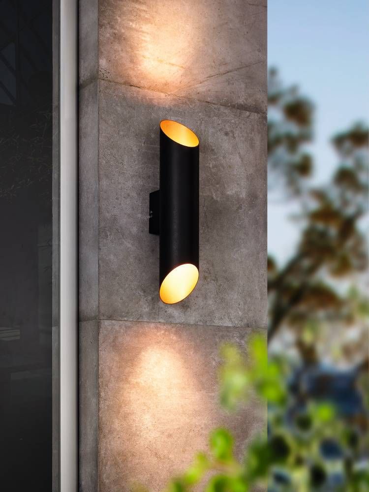 Mise en ambiance nocturne sur mur béton, lumière chaude projetée vers le haut et le bas