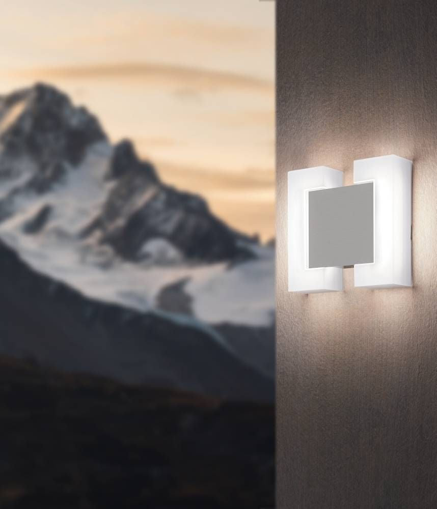 Applique extérieure blanche sur mur, montagne floue en arrière-plan doré.
