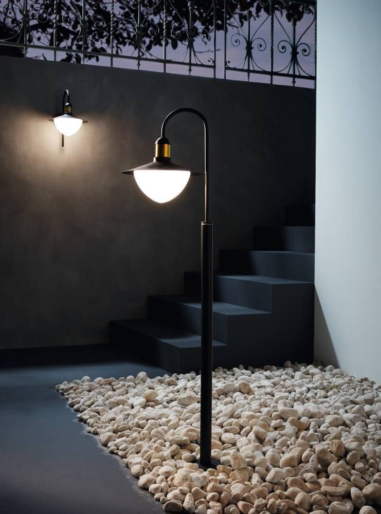 Mise en ambiance nocturne du lampadaire allumé sur graviers, près d'escaliers et d'un mur