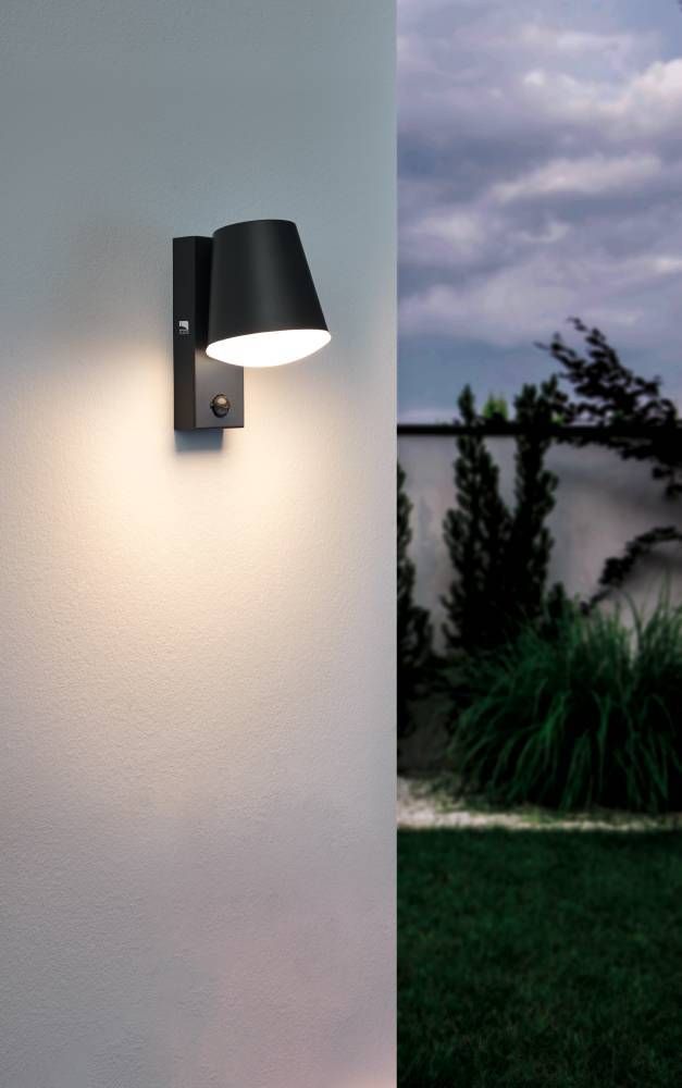 Mise en ambiance extérieure au crépuscule, mur blanc, jardin et ciel nuageux.