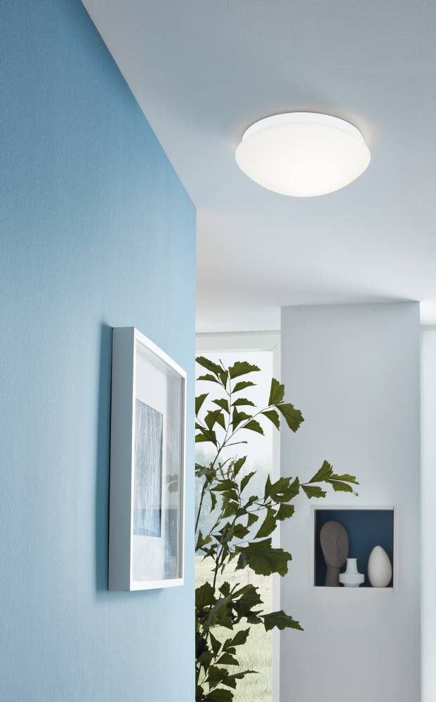 Mise en ambiance d'un plafonnier blanc allumé au plafond d'un intérieur bleu clair