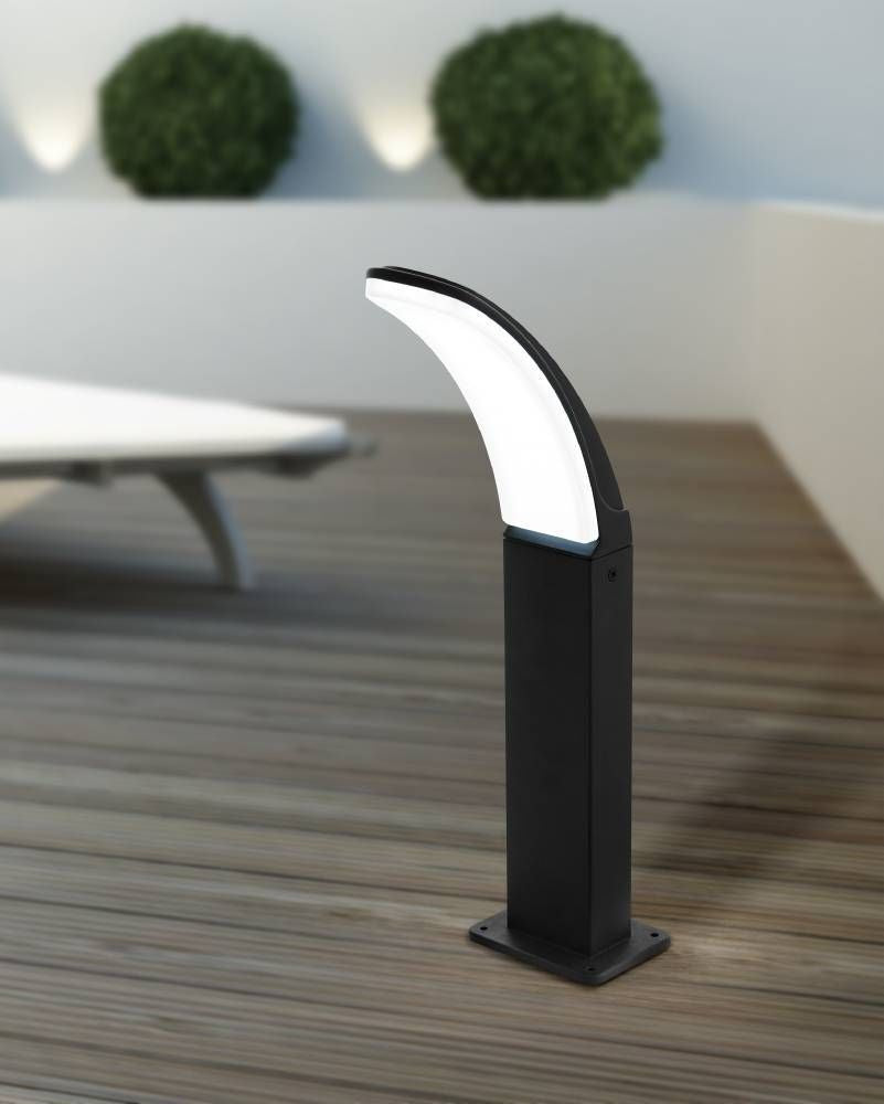 Lampadaire installé sur terrasse en bois, transats et buissons en arrière-plan