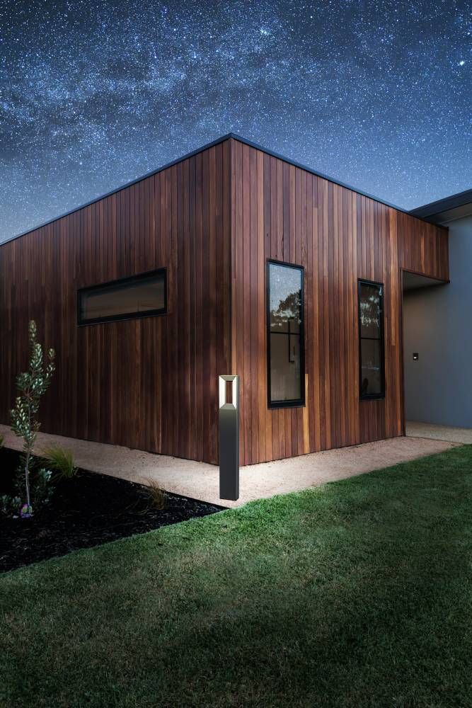 Lampadaire installé près d'une maison en bardage bois, mise en ambiance nocturne