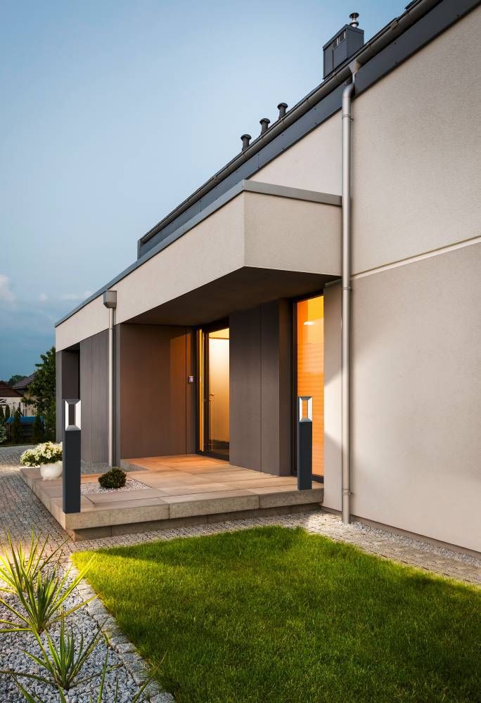 Deux lampadaires éclairant l'entrée d'une maison moderne en soirée
