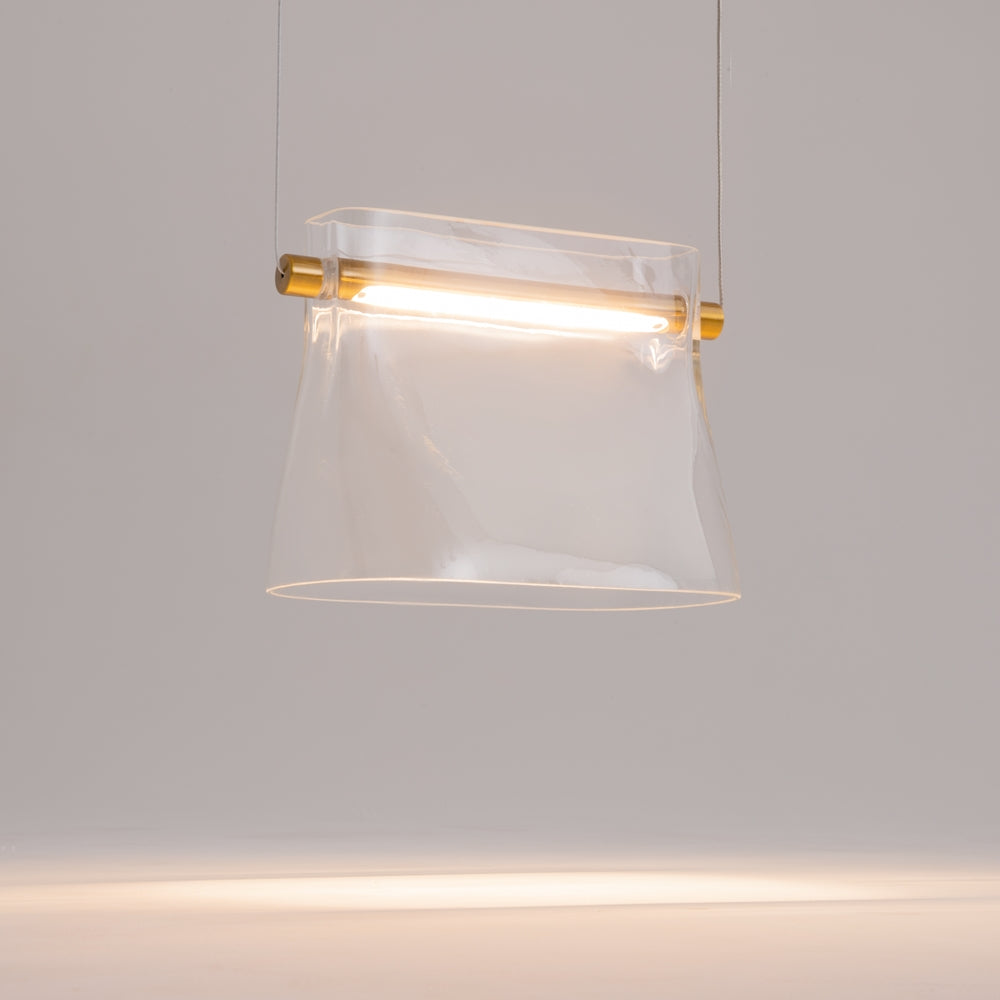 Gros plan sur l'abat-jour en verre transparent et son tube lumineux doré