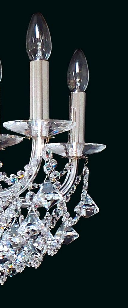 Gros plan sur les douilles, les bougies et les gouttes de cristal suspendues.
